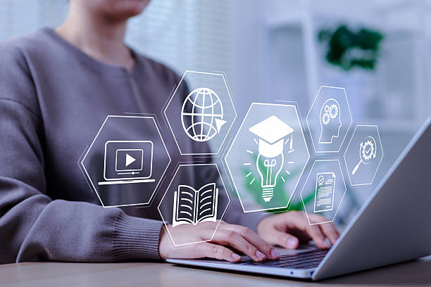 istock Online education and e-learning concept. A person use a laptop with icons representing online education, learning, knowledge sharing, educational tools, training, webinar on internet, digital courses, 2217355581