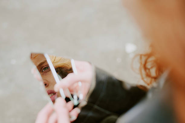 istock Reflected Woman Holding Broken Mirror Fragment 2217357160