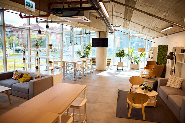 istock Modern coworking space with tables, chairs, sofas and plants 2217360017
