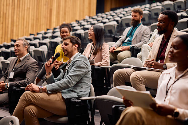istock Businessman asking a question during a conference in a congress hall 2217360118