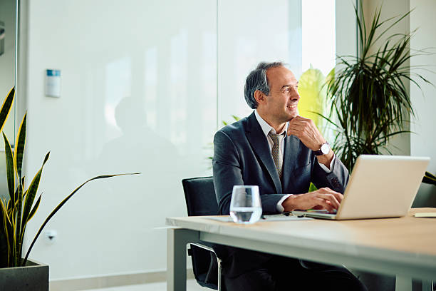 istock Pensive businessman working on laptop in modern office 2217360120
