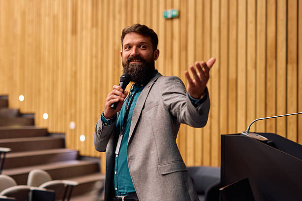 istock Motivational speaker with microphone presenting in conference hall 2217360312