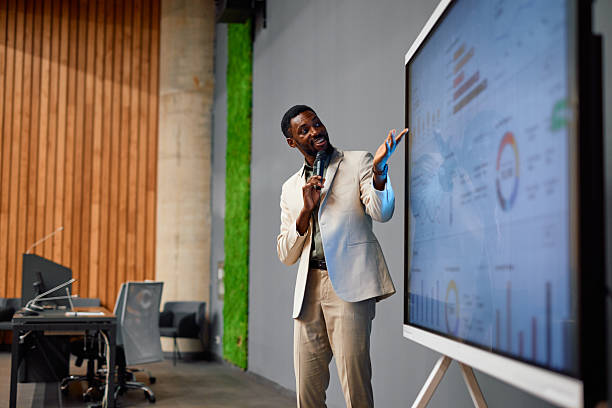 istock Confident businessman presenting marketing data on large interactive display during a meeting 2217360334