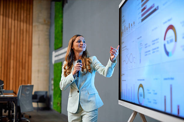 Businesswoman presenting marketing data using interactive whiteboard during a meeting