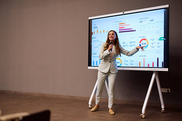 istock Young businesswoman presenting marketing data on large interactive display during a business meeting 2217360406