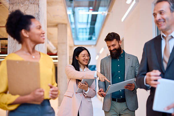 istock Business team discussing a project in office hallway 2217360522