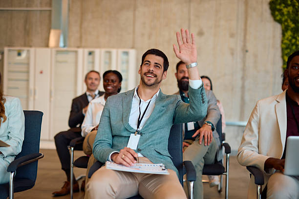 istock Businessman raising hand asking question during a conference meeting 2217360706