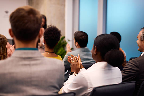 istock Audience clapping hands after a successful presentation in a modern office meeting room 2217361348