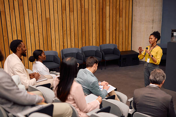 istock Confident young female speaker presenting to audience in conference room 2217361401