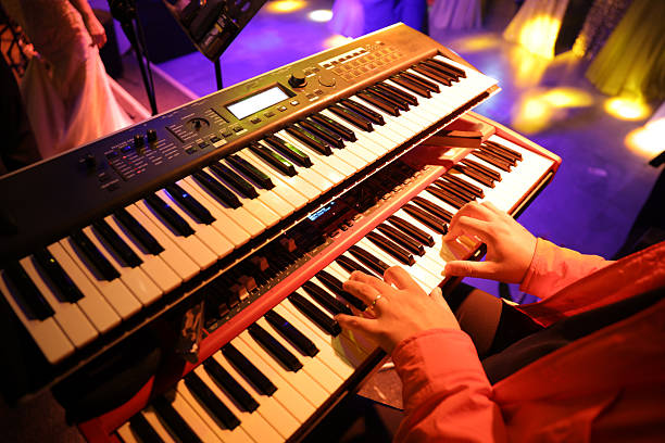 Hands of young woman touching keys of synthesizer during repetition