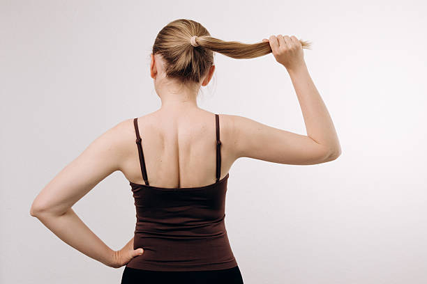 istock Woman demonstrating strength by pulling her hair back confidently, showcasing a strong posture and determination, with a neutral background emphasizing her empowered stance and self-assuredness 2217363692