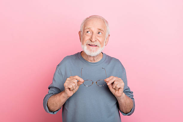 istock Photo of funky dreamy guy pensioner dressed grey pullover arms glasses looking empty space isolated pink color background 2217367499