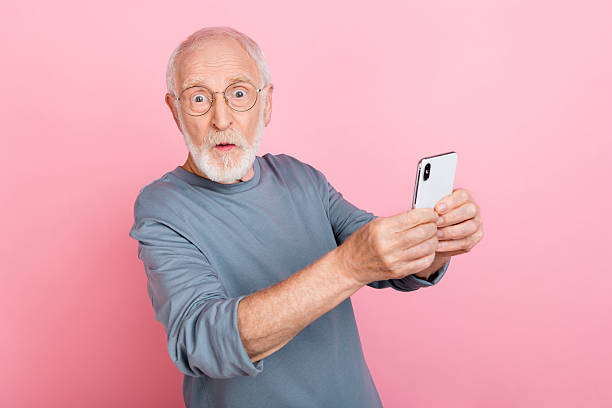 istock Photo of impressed funky guy pensioner dressed grey pullover glasses writing modern device isolated pink color background 2217367977