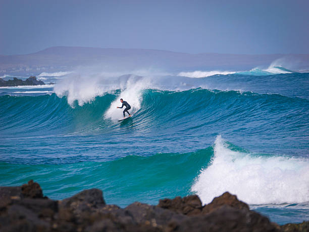 istock Skilled surfer drops in on a turquoise wave at a remote surf spot on Lanzarote 2217370242