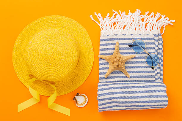 istock Beach towel with summer accessories on color background, top view 2217370296