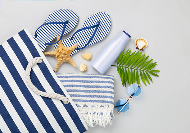istock Blue beach bag with summer accessories on color background, top view 2217370315