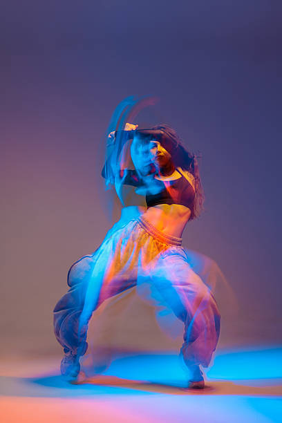 Dynamic female dancer in motion blur illuminated by vibrant neon lights performing expressive jazz-funk dance, showcasing power, rhythm, and contemporary urban style.