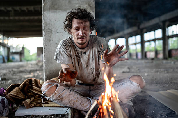 istock A Man Warming by a Fire in an Abandoned Building 2217377066