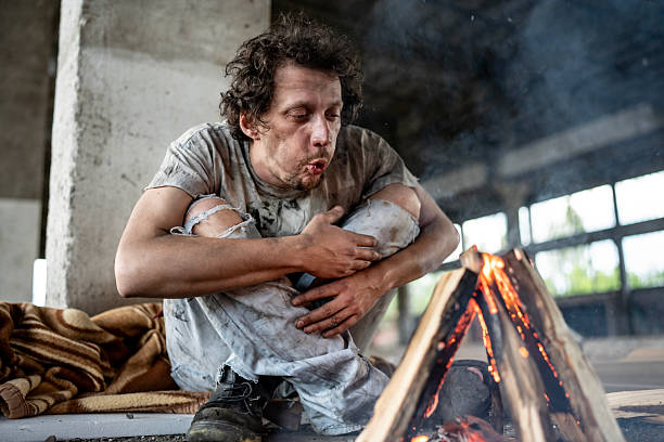 istock Man Warming Up by a Small Fire in an Urban Location 2217377076