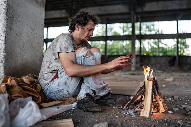 istock Homeless Man Warming Hands by a Fire in an Abandoned Building 2217377097