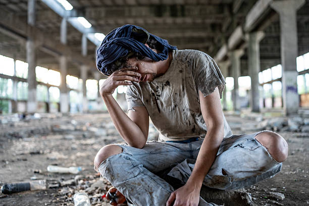 istock Distressed Person Sitting Alone in an Abandoned Urban Building 2217377203