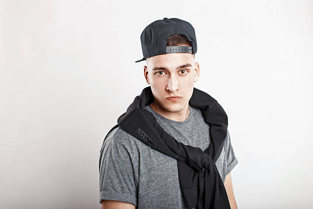 istock Young handsome guy in a baseball cap with a gray shirt on a white background 2217379697