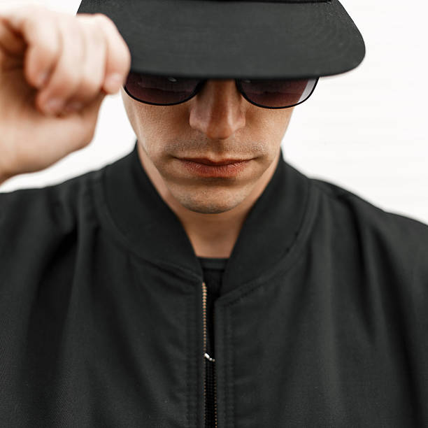 Stylish young man in sunglasses and a black cap