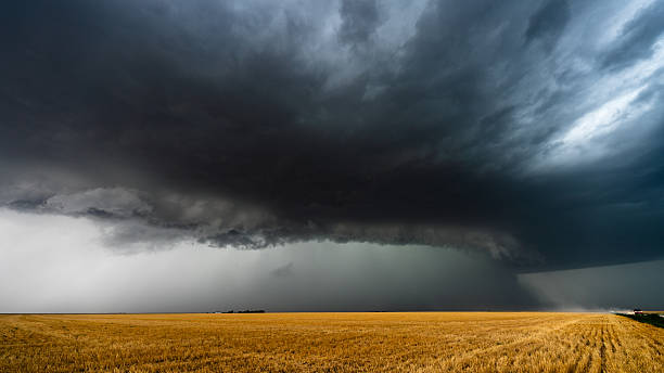 istock Big  powerful storm over fields with cars driving on dusty road 2217382266
