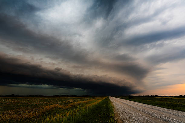 istock Ominous Storm Clouds Roll In Over a Lonely Highway Through Farmland 2217382525