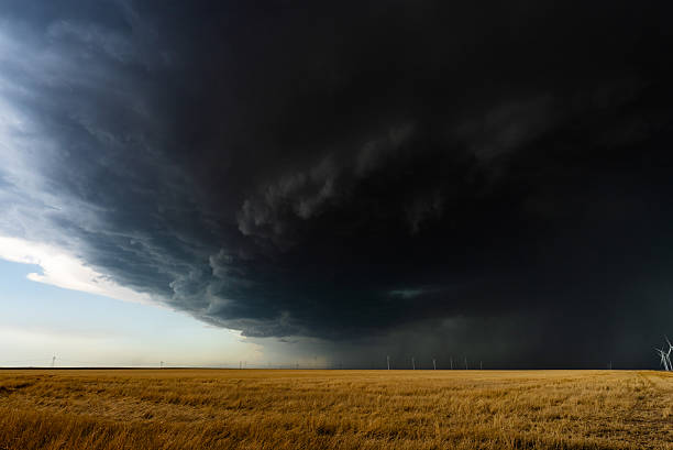 istock Storm clouds rolling across the sky over warm colored fields and wind farm 2217383127