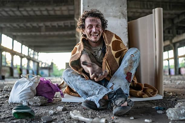 istock Smiling Man with Blanket Sitting in an Abandoned Warehouse 2217384393