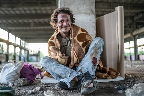 istock Smiling Man Sitting in Urban Abandoned Building with Textured Background 2217384406