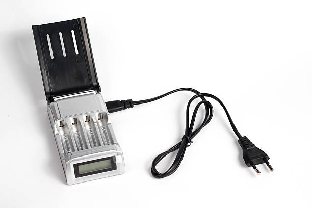 istock battery charger AA attached black cable isolated white background. 2217385404