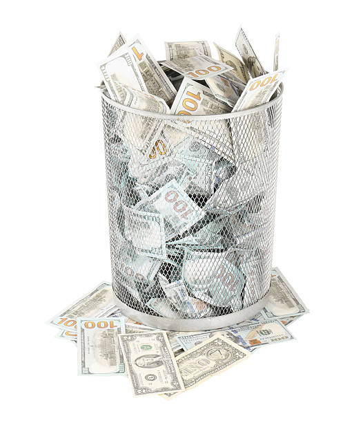 istock Many dollar banknotes in trash bin isolated on white 2217385839