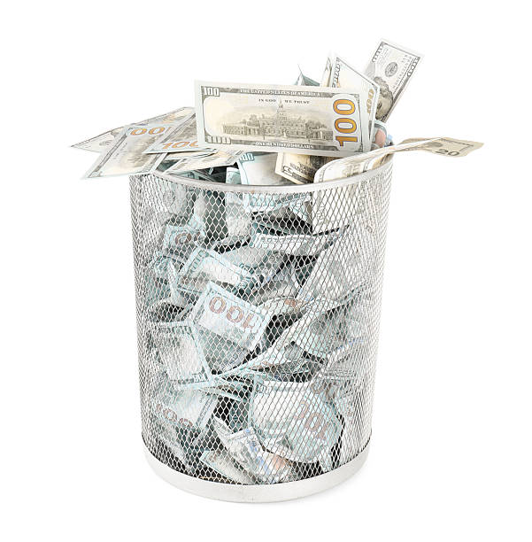 istock Many dollar banknotes in trash bin isolated on white 2217385853