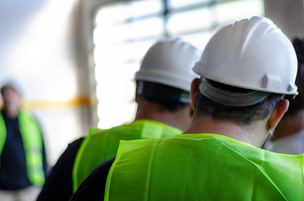 istock A group of construction workers wearing safety vests and helmets, standing together at a construction site, ready to start their teamwork on the job 2217386368