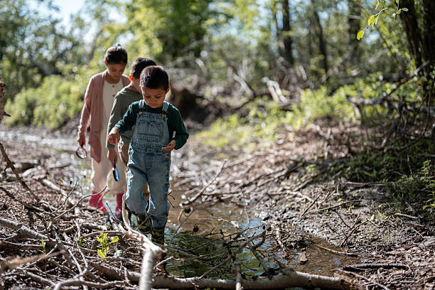 a little boy and a girl playing in the forest