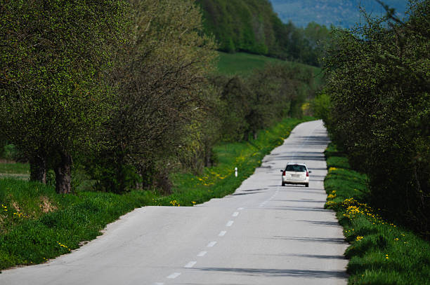 istock Country road through springtime green landscape 2217388288