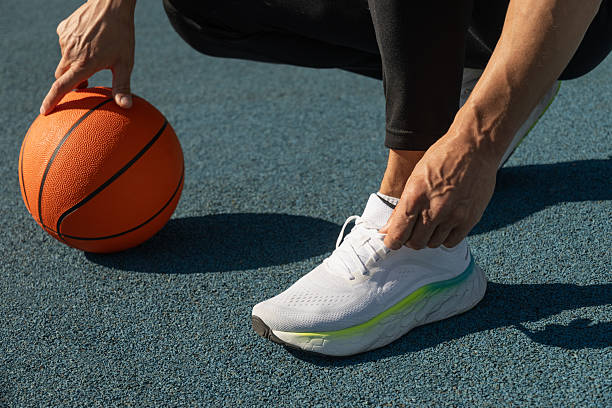 istock Basketball player tying running shoes shoelace before training. 2217388841