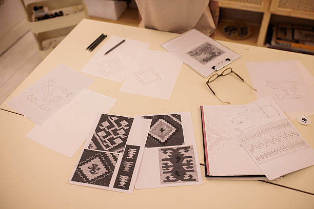 Variety of detailed pattern drafts drawn with a pencil, during a creative process in a workshop environment.