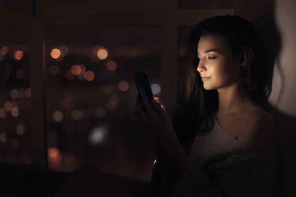 istock Beautiful Woman Illuminated By Smartphone Screen At Night 2217392423