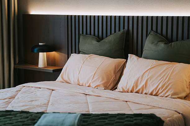 istock Modern Cozy Bedroom with Warm Lighting and Earth-Tone Bedding 2217393718