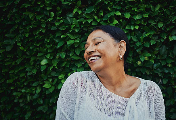 istock Joyful Woman Smiling Against Green Leafy Background 2217395821