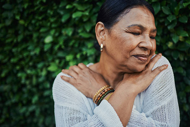 istock Serene Elderly Woman Hugging Herself in Nature 2217395876