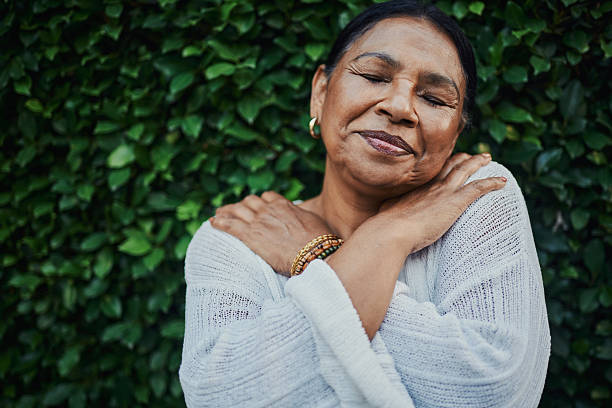 istock Serene Elderly Woman Hugging Herself in Nature 2217399061