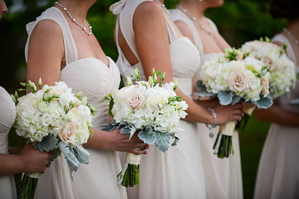 istock Bridesmaids in Matching Dresses Holding Elegant Wedding Bouquets 2217399303