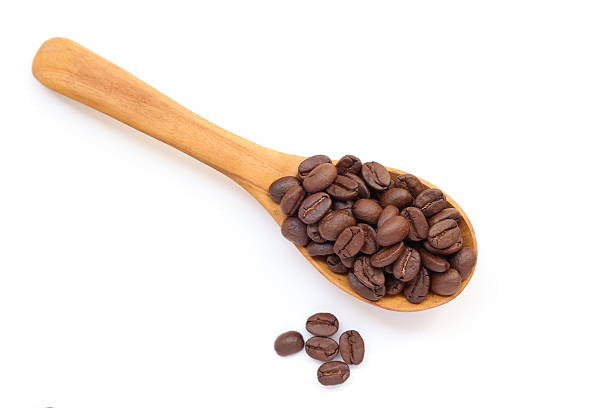 istock Brown coffee beans in spoon on white background 2217402654