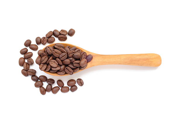 istock Brown coffee beans in spoon on white background 2217402663