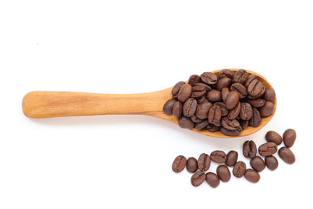 istock Brown coffee beans in spoon on white background 2217402664