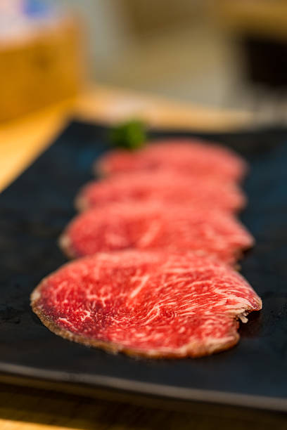 Beef tongue for grilling BBQ and hot pot served on black tray.